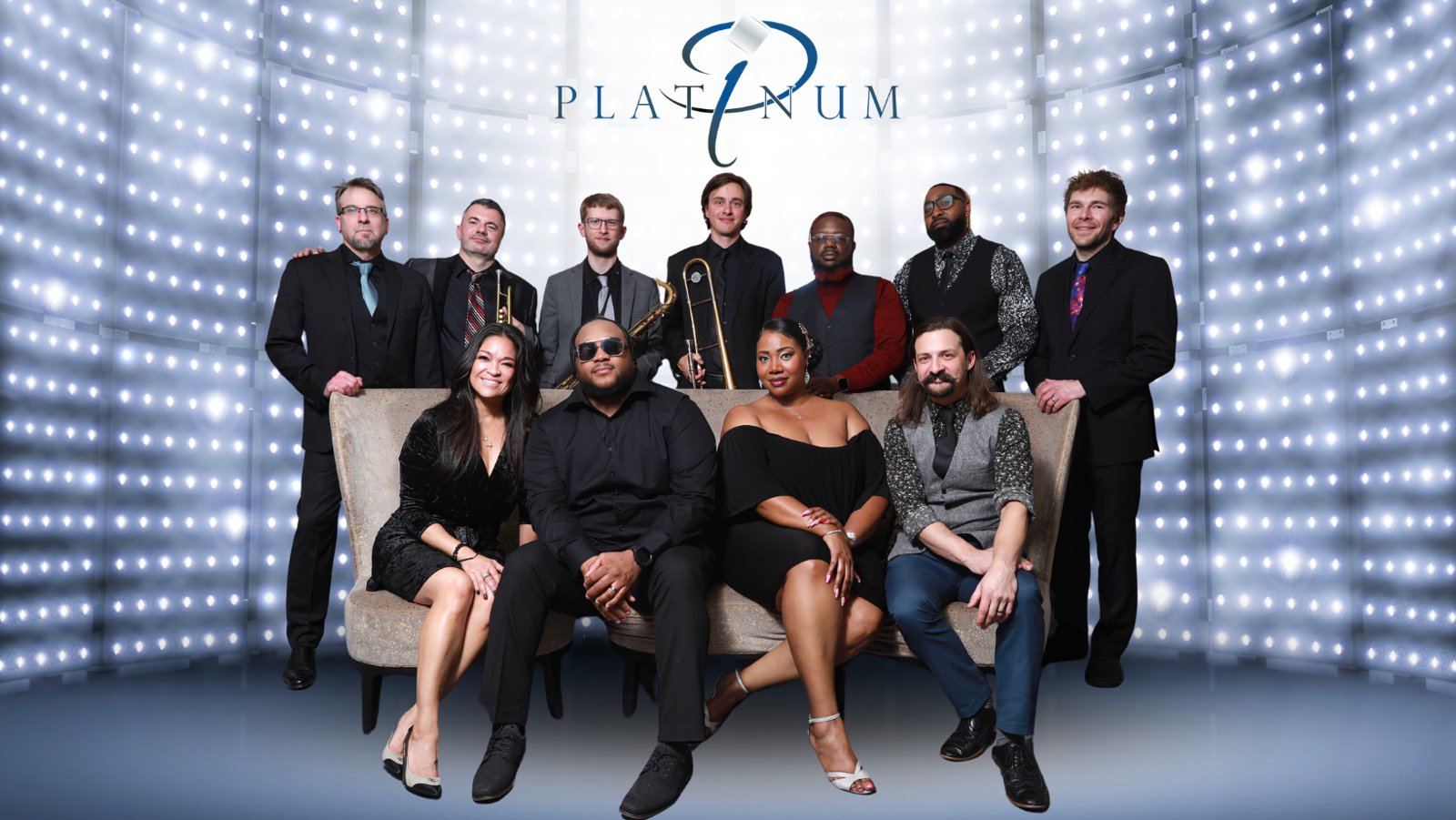 Platinum, a show band of horn players and vocalists, posed in front of a wall of lights